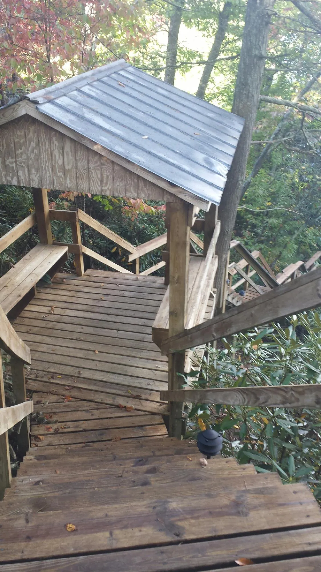 Metal roofed shelter over wooden steps on a wooded walkway — Skylight Repair & Installation work by our crew in Pomeroy